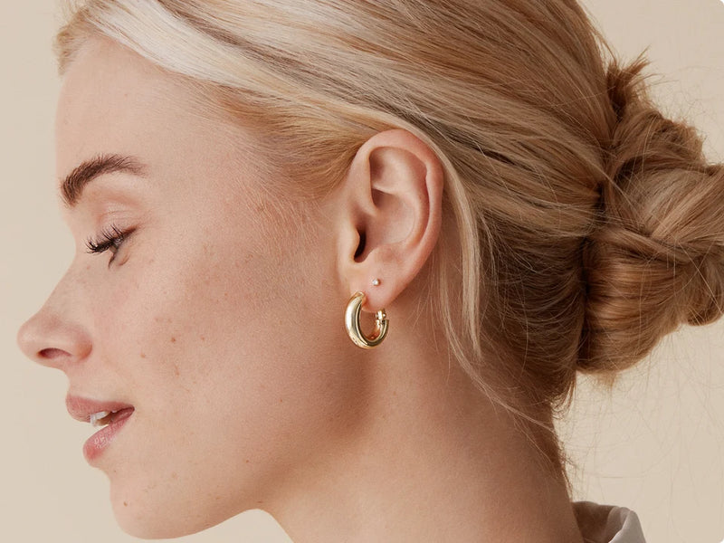 Model wearing gold earrings
